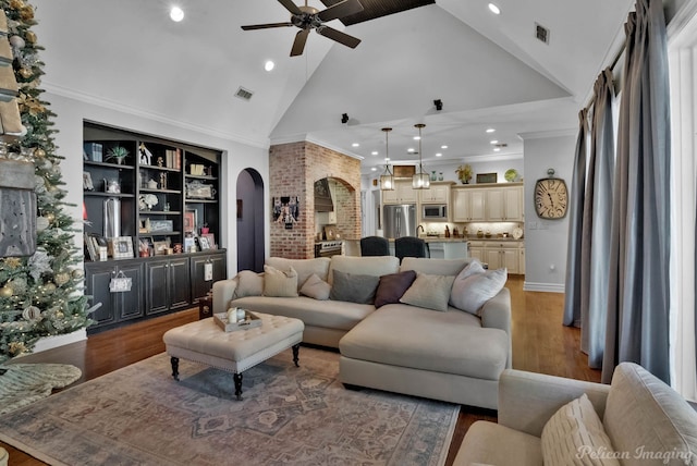 living room with crown molding, hardwood / wood-style floors, ceiling fan, and high vaulted ceiling