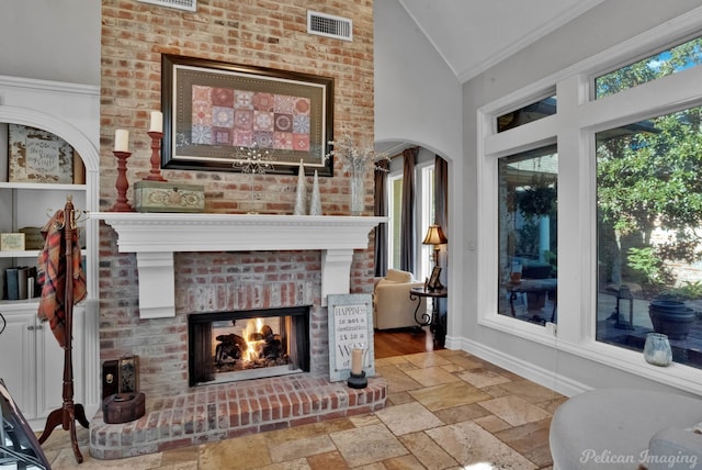 living room featuring crown molding, a fireplace, and high vaulted ceiling