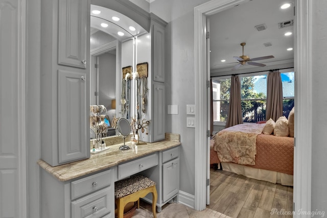 bathroom featuring hardwood / wood-style flooring, ornamental molding, vanity, and ceiling fan