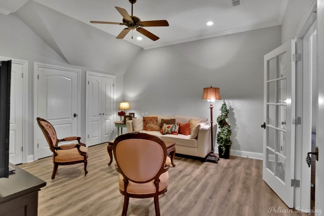 living room with crown molding, lofted ceiling, ceiling fan, and light hardwood / wood-style flooring