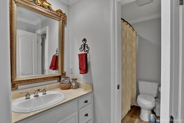 bathroom with ornamental molding, wood-type flooring, vanity, and toilet