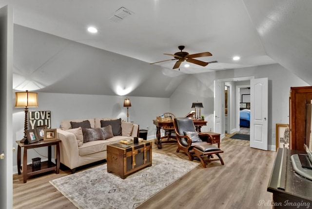 living room with light hardwood / wood-style flooring, ceiling fan, and vaulted ceiling