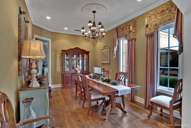 dining space featuring ornamental molding, light hardwood / wood-style flooring, and a chandelier