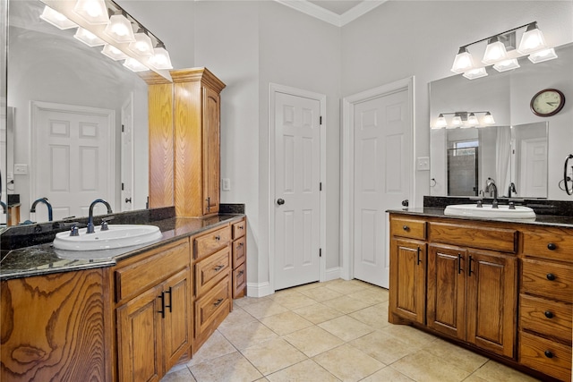 bathroom featuring tile patterned floors, vanity, a shower with shower door, and ornamental molding