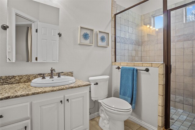 bathroom with tile patterned floors, vanity, toilet, and walk in shower