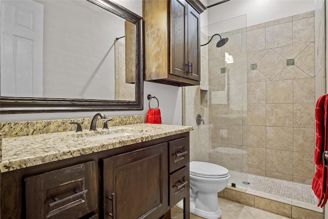 bathroom featuring tile patterned flooring, vanity, toilet, and a tile shower