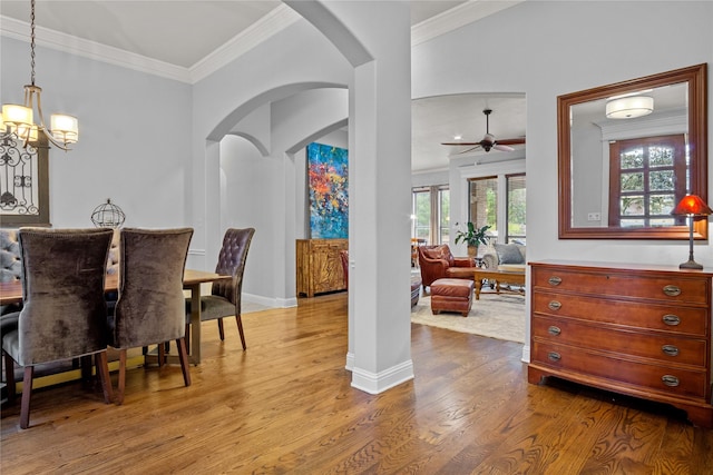 dining room with crown molding, light hardwood / wood-style floors, and ceiling fan with notable chandelier