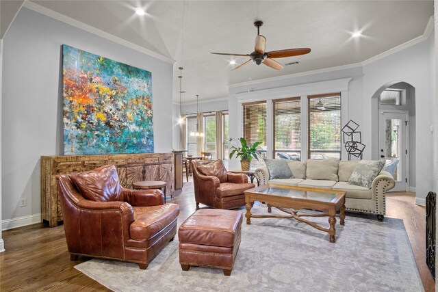 living room featuring wood-type flooring, ceiling fan, and crown molding