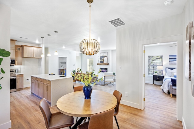 dining area featuring a notable chandelier and light hardwood / wood-style flooring