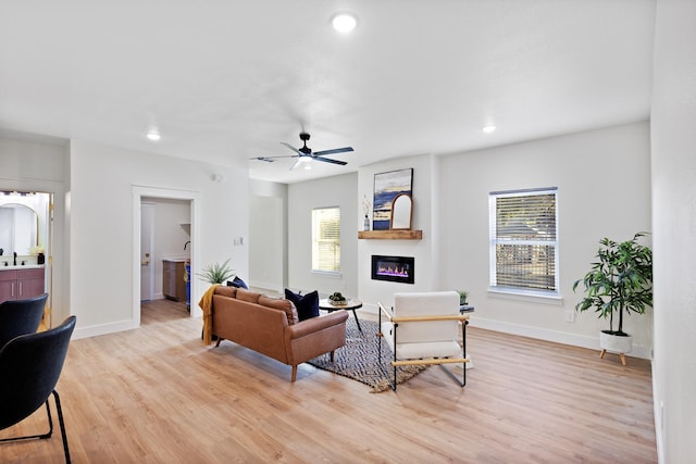 living room featuring ceiling fan, light hardwood / wood-style floors, and a wealth of natural light