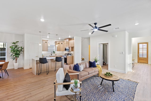 living room featuring ceiling fan and light hardwood / wood-style flooring