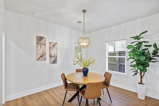 dining room with hardwood / wood-style flooring and a chandelier