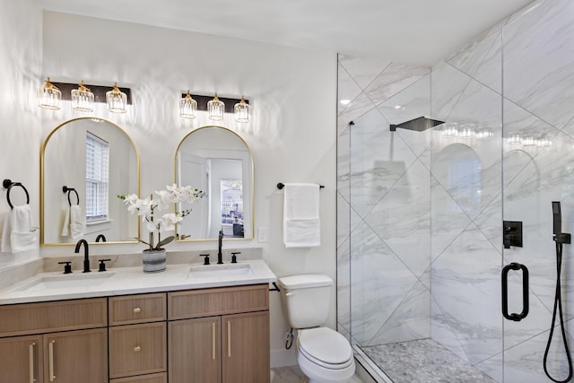 bathroom with toilet, vanity, and a shower with shower door