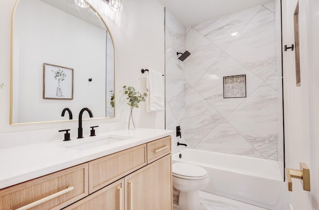 full bathroom featuring tiled shower / bath, vanity, and toilet