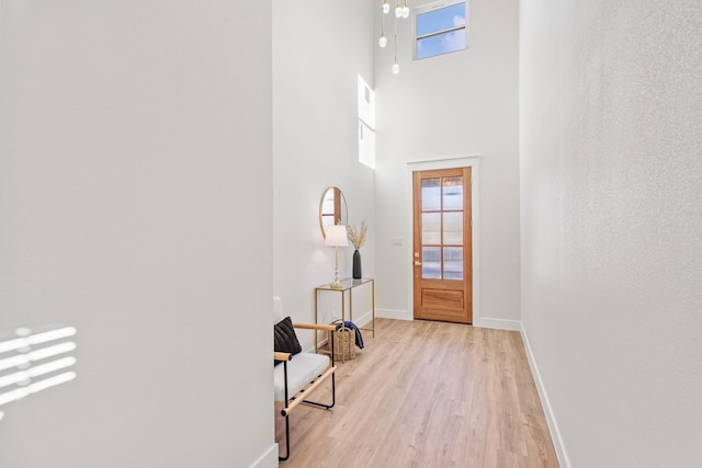 interior space featuring light hardwood / wood-style floors and a high ceiling