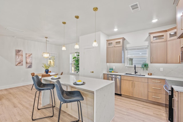 1724 S Hughes Ave, Fort Worth, TX 76105 - kitchen with stainless steel appliances, a breakfast bar, light wood-style floors, and healthy amount of natural light