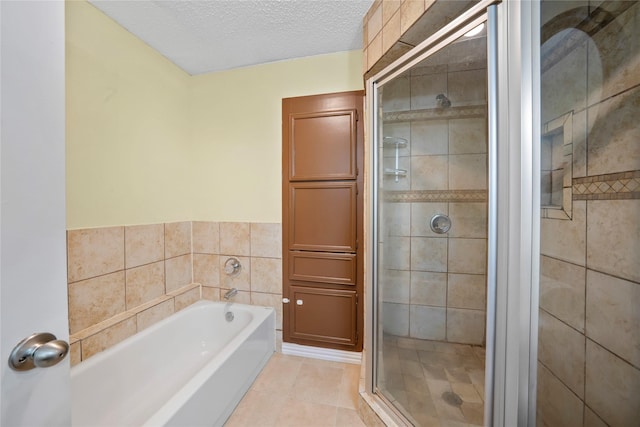 bathroom featuring tile patterned flooring, shower with separate bathtub, a textured ceiling, and tile walls