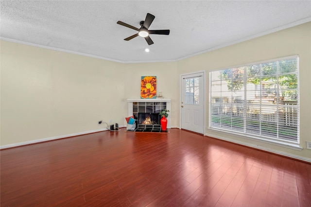 interior space with hardwood / wood-style flooring, a healthy amount of sunlight, a textured ceiling, and a tile fireplace