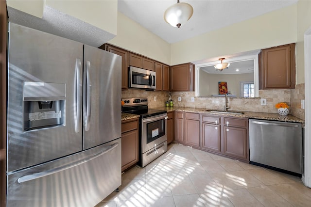 kitchen with light tile patterned floors, backsplash, stainless steel appliances, and sink