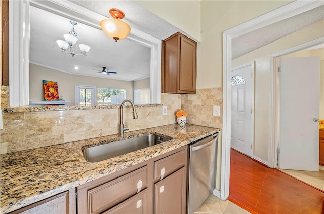 kitchen featuring a textured ceiling, ceiling fan with notable chandelier, sink, dishwasher, and light hardwood / wood-style floors