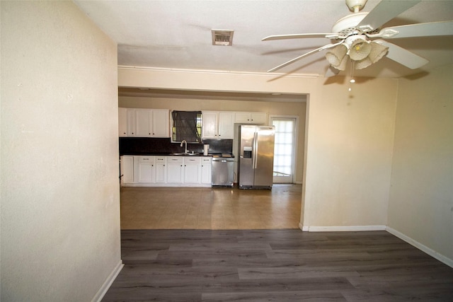 kitchen with white cabinetry, sink, decorative backsplash, stainless steel appliances, and dark wood-type flooring