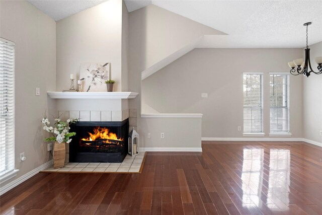 unfurnished living room with a healthy amount of sunlight, lofted ceiling, and wood-type flooring