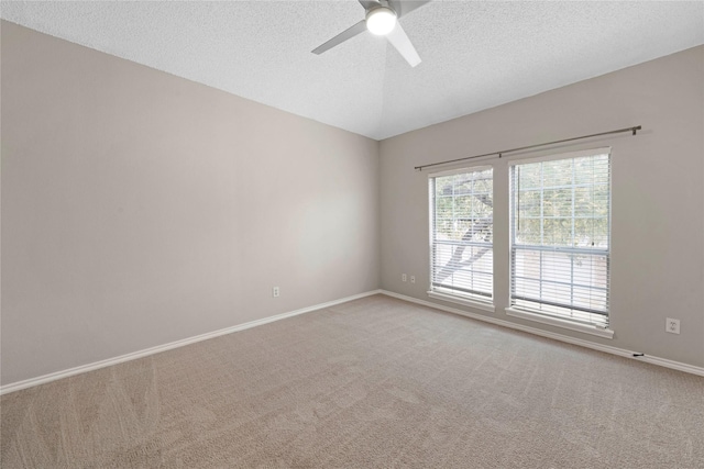 carpeted empty room featuring ceiling fan, lofted ceiling, and a textured ceiling