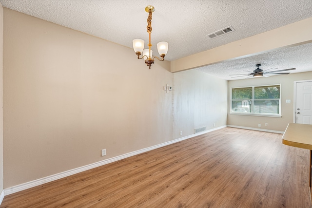 unfurnished room with ceiling fan with notable chandelier, hardwood / wood-style floors, and a textured ceiling