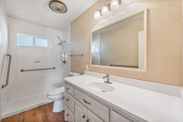 bathroom with hardwood / wood-style flooring, vanity, toilet, and a textured ceiling