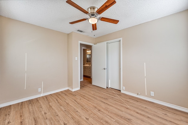 unfurnished bedroom with a textured ceiling, light hardwood / wood-style flooring, and ceiling fan