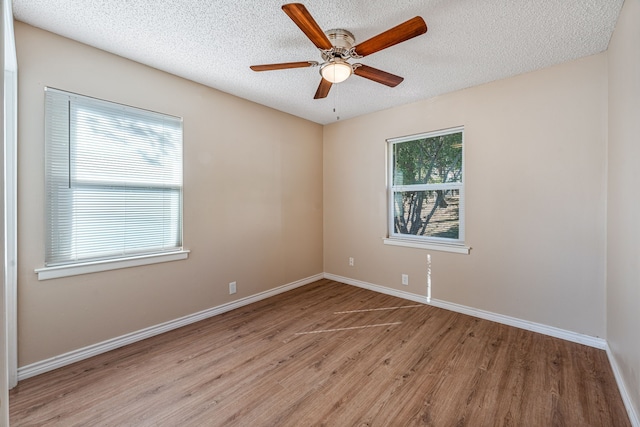 empty room with ceiling fan, a textured ceiling, and light wood-type flooring