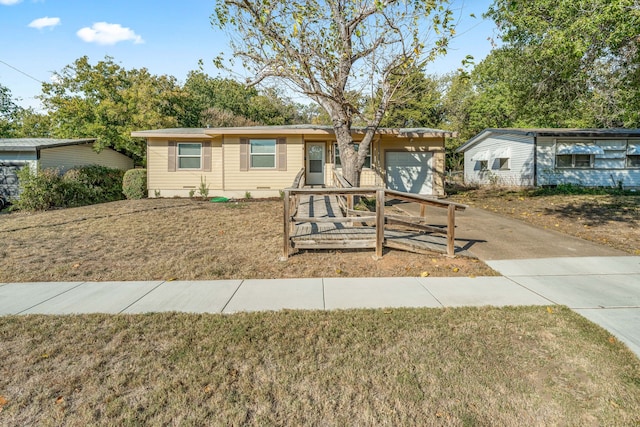 ranch-style house featuring a front lawn and a garage