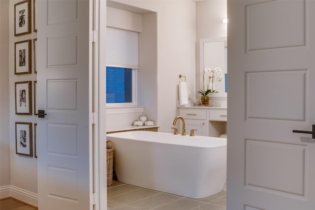 bathroom with tile patterned floors and a bath