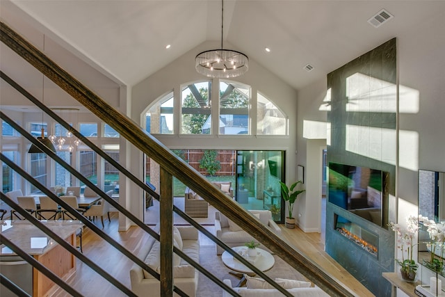 interior space featuring high vaulted ceiling, hardwood / wood-style flooring, and an inviting chandelier