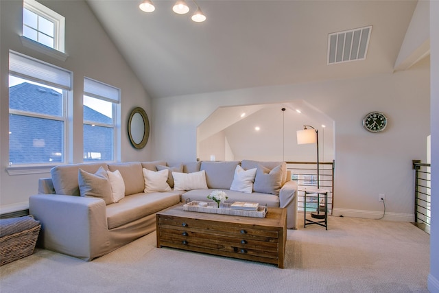 living room with light carpet and high vaulted ceiling