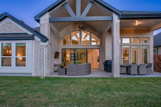 back of house featuring outdoor lounge area, ceiling fan, a patio area, and a yard