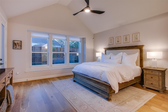 bedroom with ceiling fan, light hardwood / wood-style flooring, and high vaulted ceiling