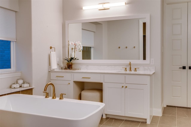 bathroom with tile patterned floors, a bathtub, and vanity