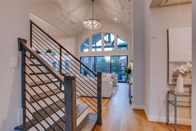 interior space featuring a chandelier, light wood-type flooring, and vaulted ceiling