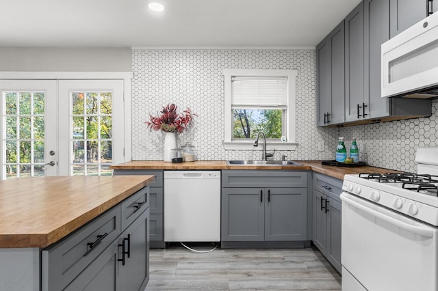 kitchen with gray cabinetry, white appliances, and sink