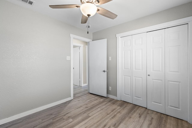 unfurnished bedroom featuring ceiling fan, a closet, and light hardwood / wood-style floors