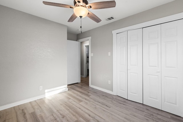 unfurnished bedroom featuring a closet, light hardwood / wood-style flooring, and ceiling fan