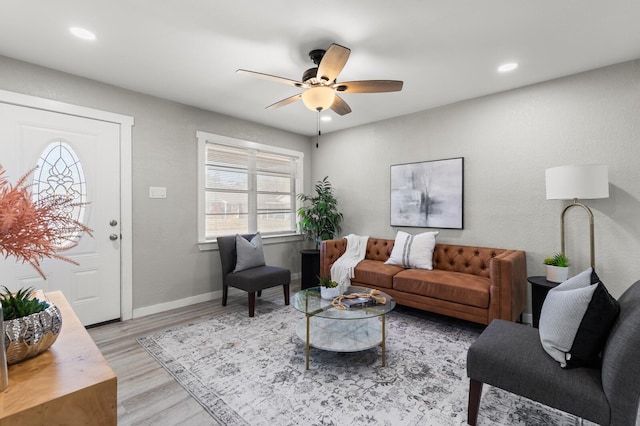 living room with ceiling fan and light wood-type flooring