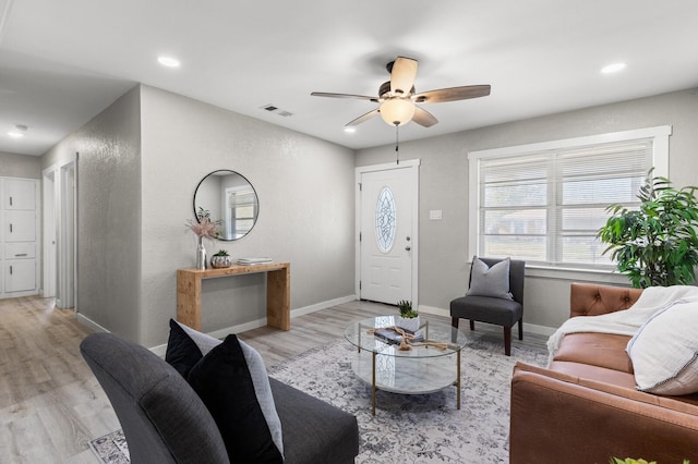 living room featuring light hardwood / wood-style floors and ceiling fan