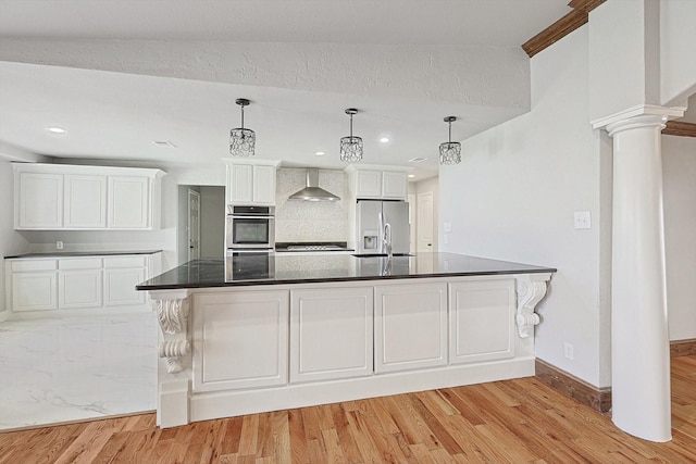 kitchen with white cabinetry, wall chimney exhaust hood, light wood-type flooring, and appliances with stainless steel finishes