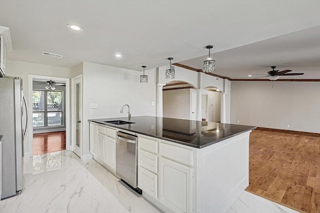 kitchen with sink, white cabinetry, stainless steel appliances, and an island with sink