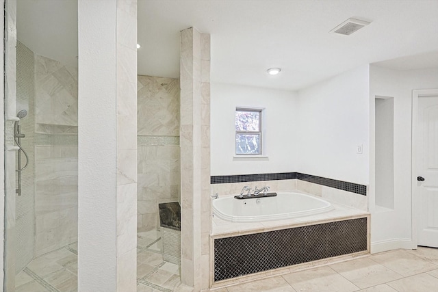 bathroom with tile patterned floors and shower with separate bathtub