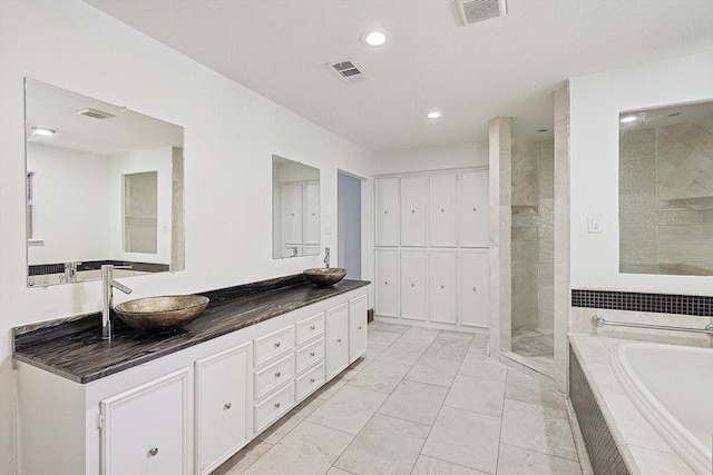 bathroom with vanity and shower with separate bathtub