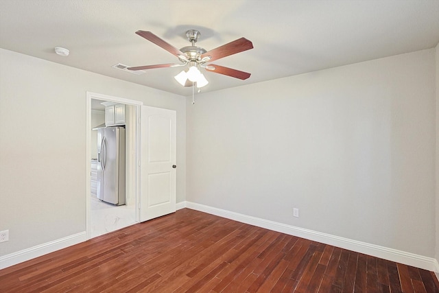 unfurnished bedroom featuring hardwood / wood-style flooring, ceiling fan, and stainless steel refrigerator with ice dispenser