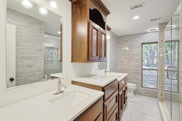 bathroom with vanity, toilet, and tile walls